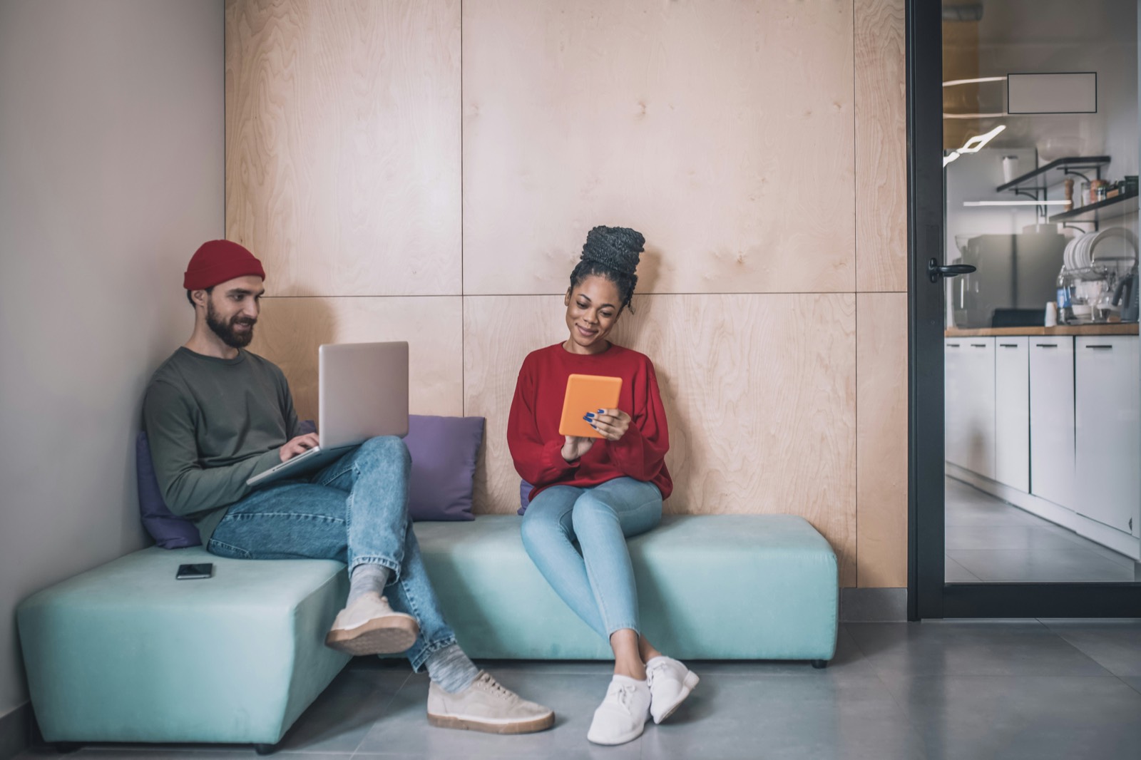 Two colleagues working together in an office lounge